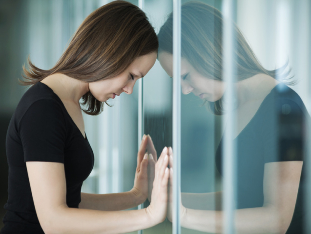 young woman  woman leaned against glass wall in crisis moment