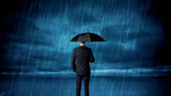 Business man standing in rain with an umbrella concept on background